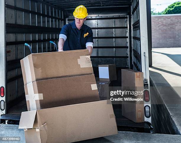 lieferung arbeiter laden beschädigte boxen auf hand truck - unloading stock-fotos und bilder