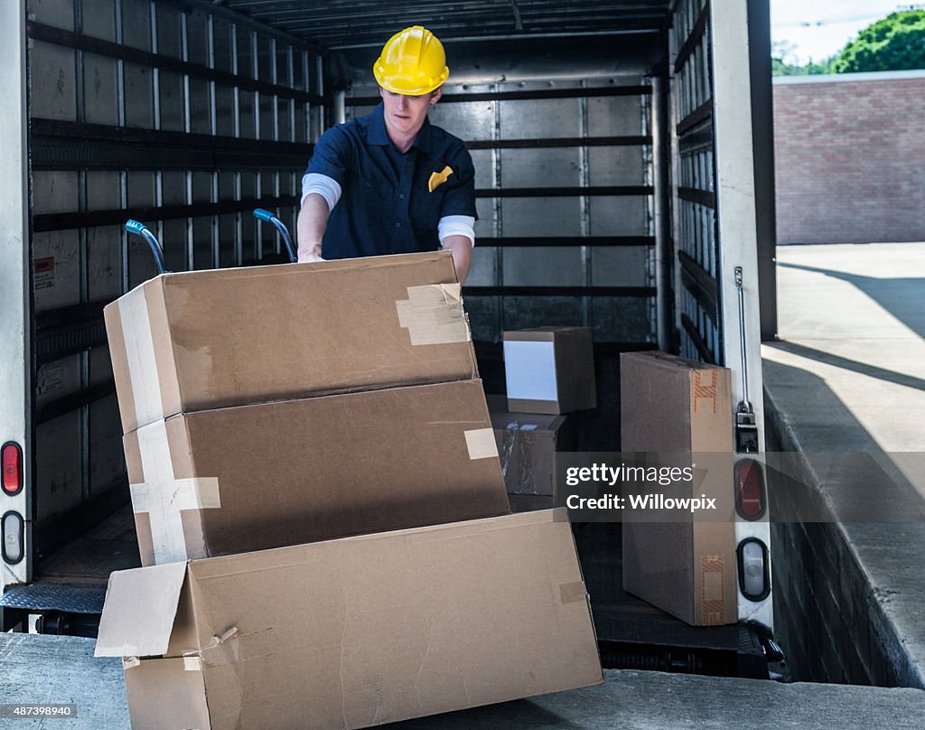 Delivery Worker Loading Damaged Boxes On Hand Truck