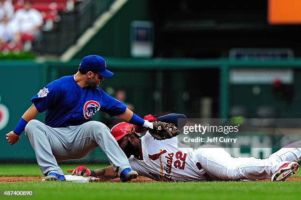 Jason Heyward of the St. Louis Cardinals slides safely past the tag of Tommy La Stella of the Chicago Cubs for a stolen base during the first inning...