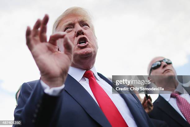 Republican presidential candidate Donald Trump talks with journalists during a rally against the Iran nuclear deal on the West Lawn of the U.S....