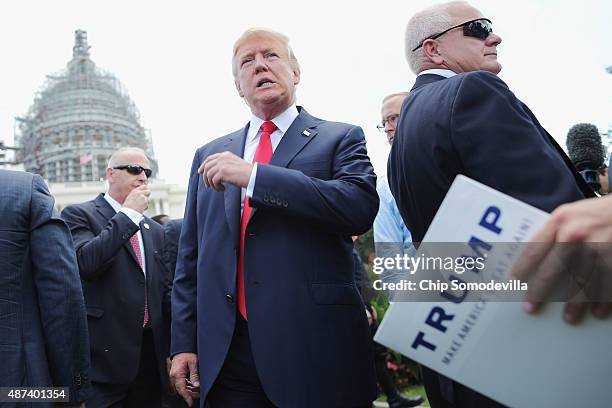 Republican presidential candidate Donald Trump talks with journalists during a rally against the Iran nuclear deal on the West Lawn of the U.S....