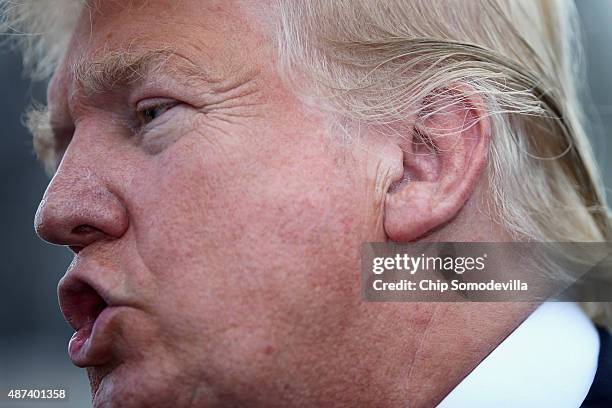 Republican presidential candidate Donald Trump talks with journalists during a rally against the Iran nuclear deal on the West Lawn of the U.S....