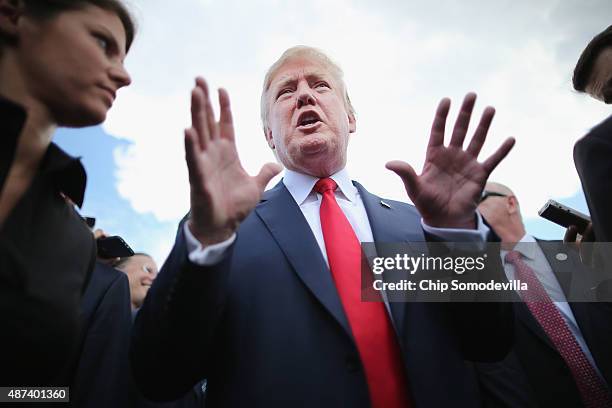 Republican presidential candidate Donald Trump talks with journalists during a rally against the Iran nuclear deal on the West Lawn of the U.S....