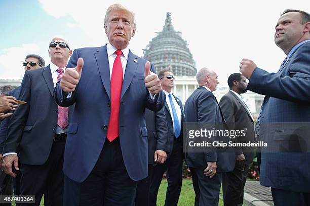 Republican presidential candidate Donald Trump gives a thumbs up to photographers during a rally against the Iran nuclear deal on the West Lawn of...