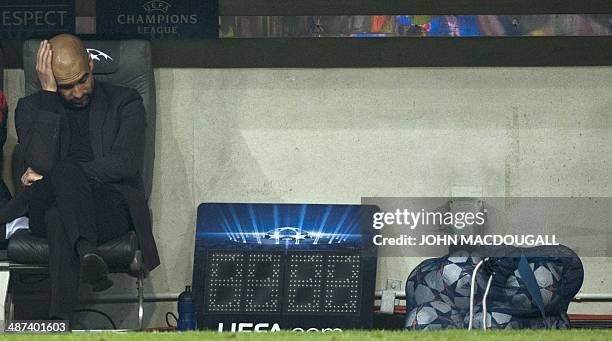 Munich's coach Pep Guardiola of Spain holds his head at the end of the UEFA Champions League second-leg semi-final football match FC Bayern Munich vs...
