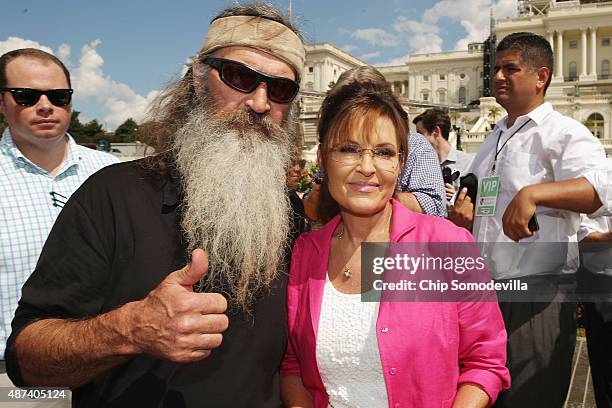 Reality television personality Phil Robertson and Sarah Palin pose for photographs during a rally against the Iran nuclear deal on the West Lawn of...