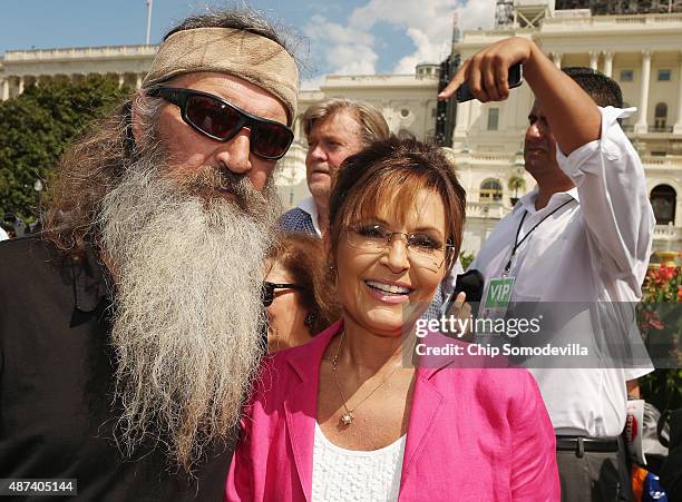 Reality television personality Phil Robertson and Sarah Palin pose for photographs during a rally against the Iran nuclear deal on the West Lawn of...