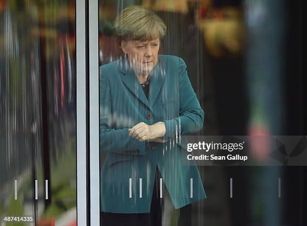 German Chancellor Angela Merkel waits for the arrival of Japanese Prime Minister Shinzo Abe inside a glass door of the Chancellery on April 30, 2014...