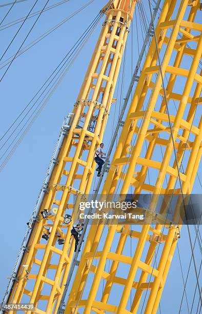 Sam Branson and Noah Devereux scale the 02 Arena during a photocall to launch the Virgin STRIVE Challenge held at the 02 Arena on April 30, 2014 in...