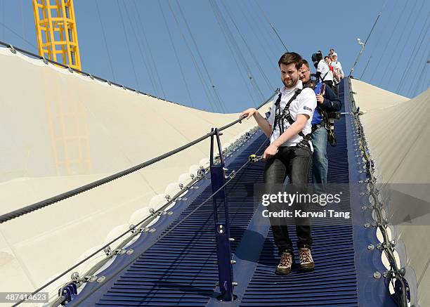 Jack Whitehall scales the 02 Arena during a photocall to launch the Virgin STRIVE Challenge held at the 02 Arena on April 30, 2014 in London, England.