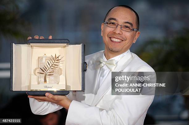 Thai director Apichatpong Weerasethakul poses after receiving the Palme dOr award for his film "Lung Boonmee Raluek Chat" during the closing ceremony...