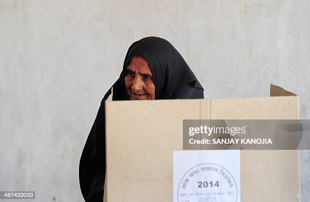 An Indian Muslim woman casts her ballot at a polling station in Rae Bareli on April 30, 2014. India's 814-million-strong electorate is voting in the...