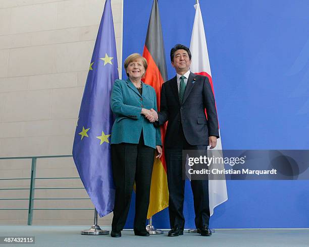 German Chancellor Angela Merkel and the Japanese Prime Minister Shinzo Abe shake hands following talks at the Chancellery on April 30, 2014 in...