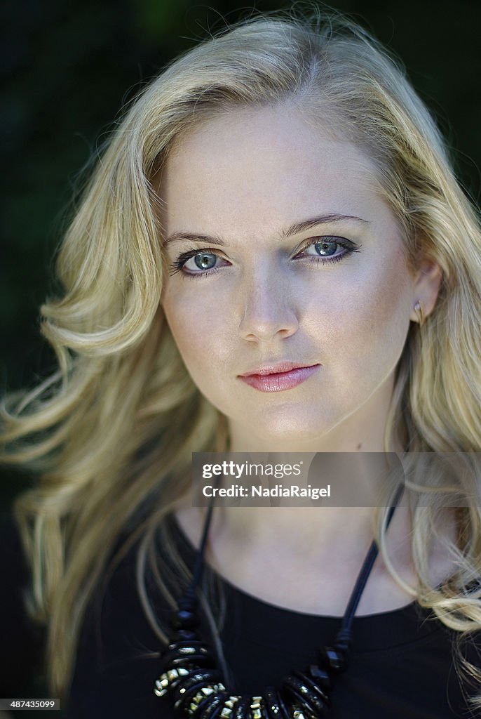 Blue-eyed blonde girl on black background