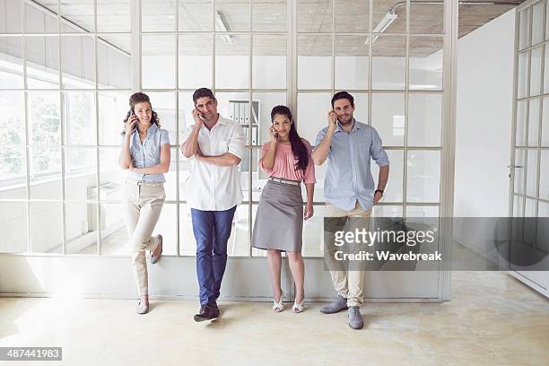 business team using mobile phones in row at office - man standing full length stock pictures, royalty-free photos & images
