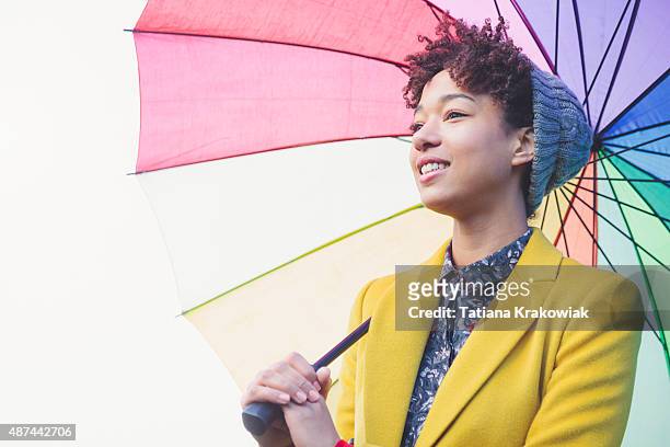 woman in beanie hat under colorful umbrella (london, uk) - female fashion with umbrella stock pictures, royalty-free photos & images