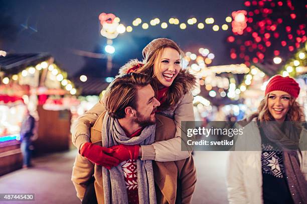 couple having fun outdoors at winter fair. - christmas couple stockfoto's en -beelden