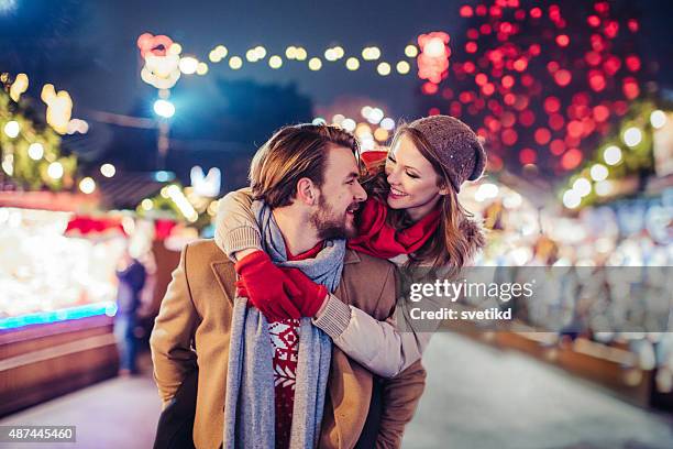 couple having fun outdoors at winter fair. - vienna holiday fair stock pictures, royalty-free photos & images