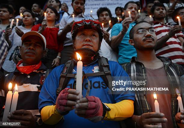 Nepalese people holds candles in memory of the 16 Nepalese Sherpa guides killed in an avalanche on Mount Everest in Katmandu on April 30, 2014. An...