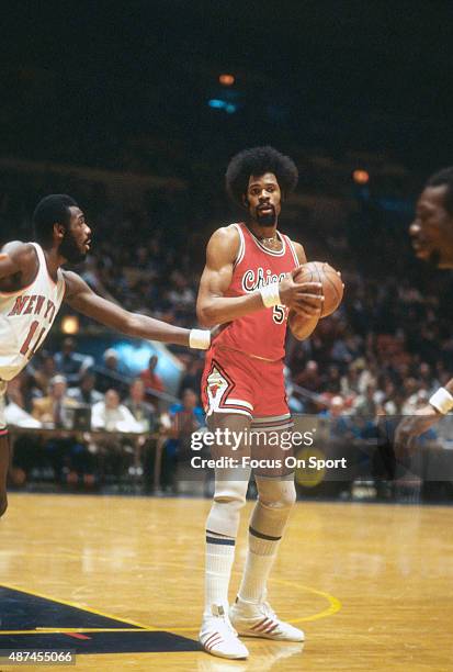 Artis Gilmore of the Chicago Bulls looks to pass the ball while defended by Bob McAdoo of the New York Knicks during an NBA basketball game circa...