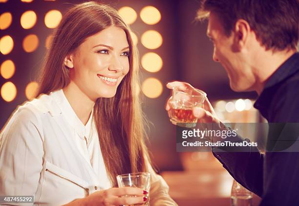 pareja disfrutando de un whisky - community spirit fotografías e imágenes de stock