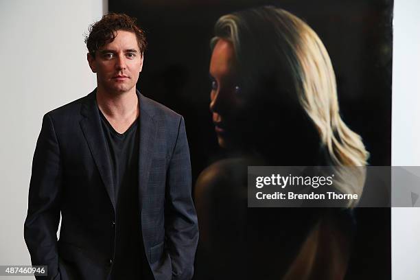 Artist, Vincent Fantauzzo poses in front of his portrait unveiling of Charlize Theron on September 10, 2015 in Sydney, Australia.
