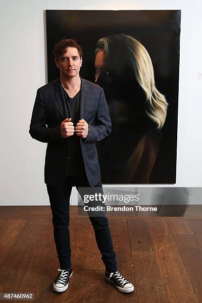 Artist, Vincent Fantauzzo poses in front of his portrait unveiling of Charlize Theron on September 10, 2015 in Sydney, Australia.