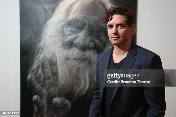 Artist, Vincent Fantauzzo poses in front of his portrait 'Kudditji' on September 10, 2015 in Sydney, Australia.