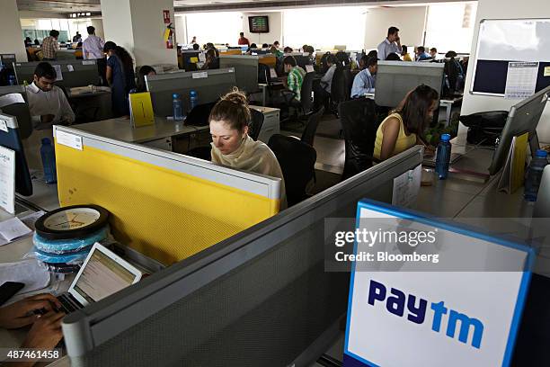 Employees work at their desks at the One97 Communications Ltd. Headquarters in Noida, Uttar Pradesh, India, on Thursday, May 14, 2015. One97, which...