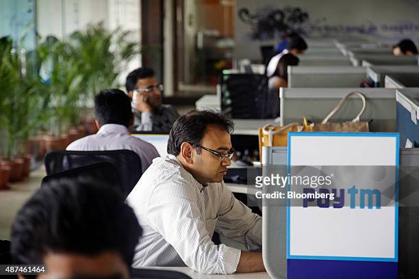 Employees work at their desks at the One97 Communications Ltd. Headquarters in Noida, Uttar Pradesh, India, on Thursday, May 14, 2015. One97, which...