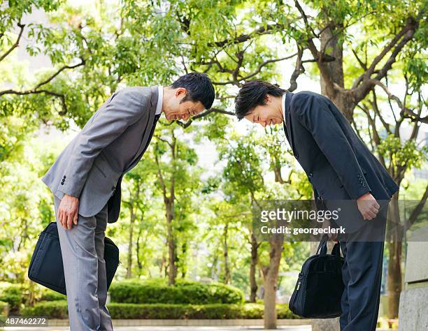 japanese businessmen bowing to each other - bowing stock pictures, royalty-free photos & images