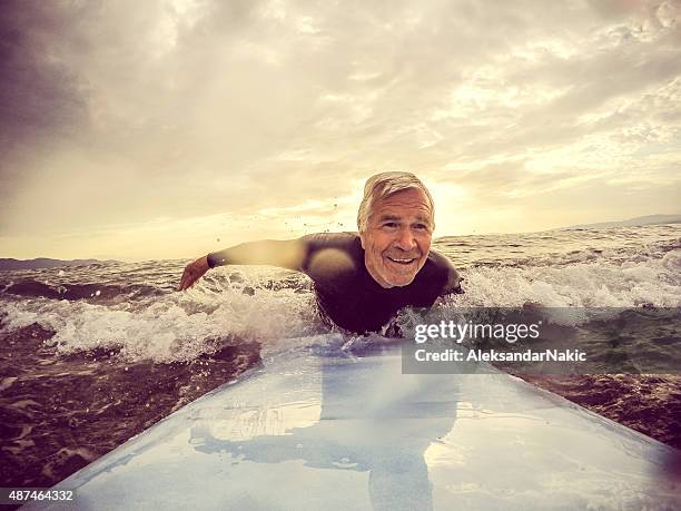 forever young - man surfing photos et images de collection