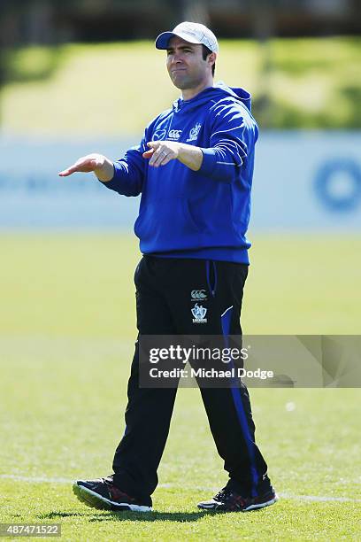 Kangaroos head coach Brad Scott gestures to his communications manager to stop media filming Daniel Wells doing his fitness test midway through a...