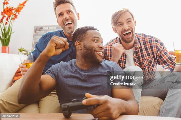 three guys playing video games - game three stockfoto's en -beelden