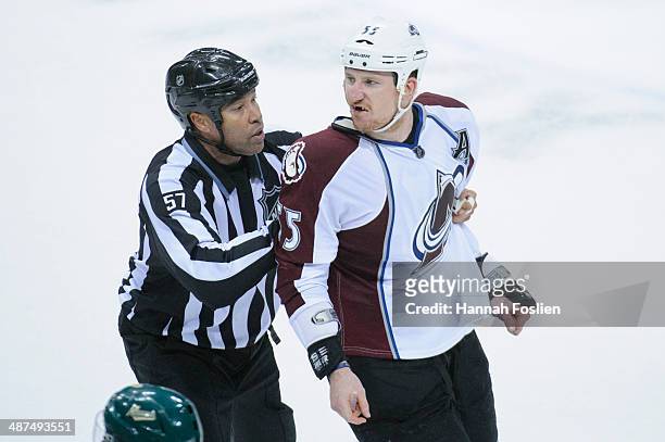Linesman Jay Sharrers escorts Cody McLeod of the Colorado Avalanche off the ice after the Minnesota Wild won Game Six of the First Round of the 2014...