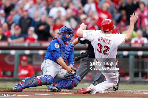 Jay Bruce of the Cincinnati Reds slides at home plate ahead of the tag by Welington Castillo of the Chicago Cubs in the first inning of the game at...