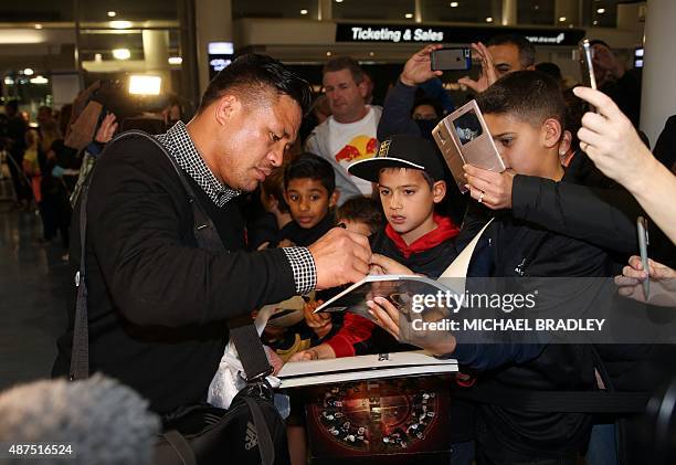 New Zealand All Blacks Keven Mealamu signs autographs at the Auckland International Airport in Auckland on September 10, 2015 before departing to the...