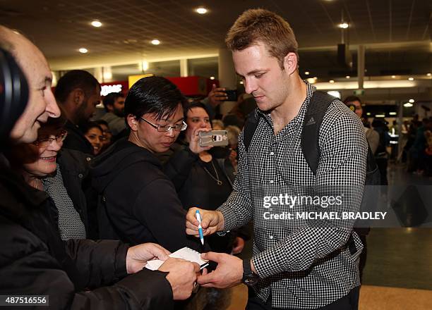 New Zealand All Blacks Sam Kane signs autographs at the Auckland International Airport in Auckland on September 10, 2015 before departing to the...