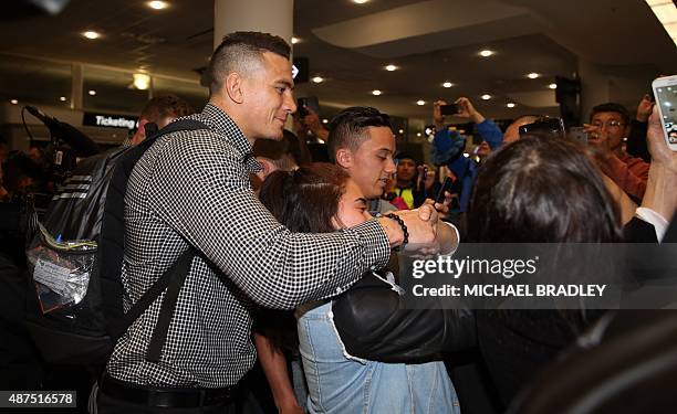New Zealand All Blacks Sonny Bill Williams talks to fans at the Auckland International Airport in Auckland on September 10, 2015 before departing to...