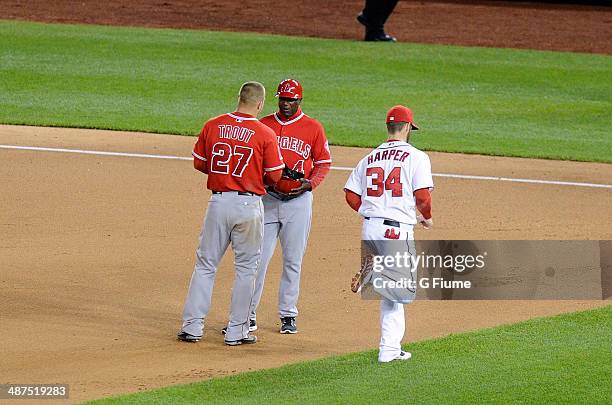 Bryce Harper of the Washington Nationals runs by Mike Trout of the Los Angeles Angels between innings of the game at Nationals Park on April 23, 2014...