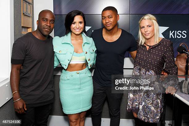 Demi Lovato poses with KISS Breakfast presenters Rickie Haywood Williams, Charlie Hedges and Melvin O'Doom as she visits Kiss FM Studio's on...