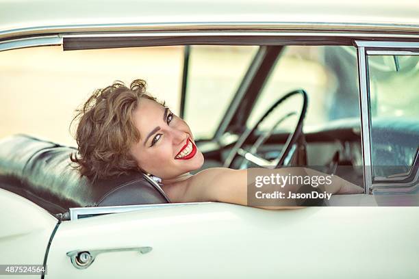 happy 1950s  woman smiling and lauging in a vintage car - rockabilly stock pictures, royalty-free photos & images