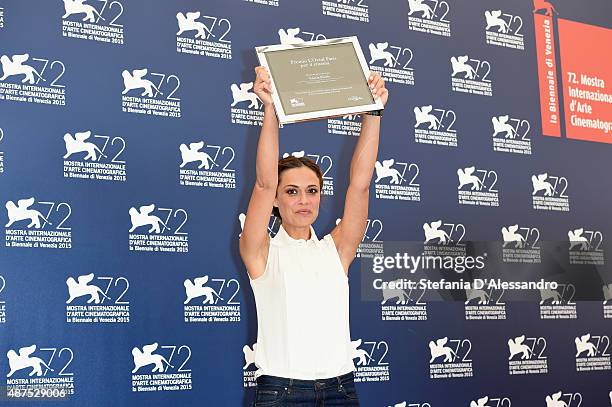 Winner Valeria Bilello poses with her 'L'Oreal Paris per il Cinema' award as she attends the photocall for the L'Oreal Paris Award For Cinema during...