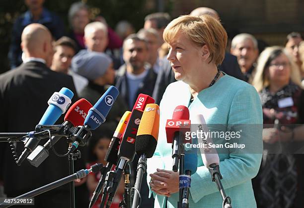 German Chancellor Angela Merkel speaks to the media after she visited the AWO Refugium Askanierring shelter for migrants on September 10, 2015 in...