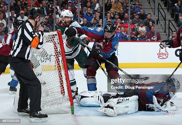 Goalie Semyon Varlamov of the Colorado Avalanche covers the puck as Nick Holden of the Colorado Avalanche defends the crease against Jason Pominville...