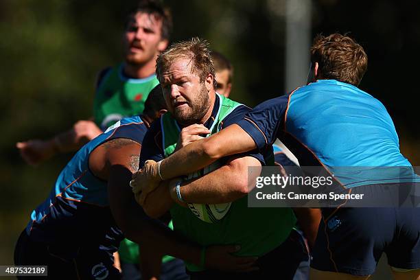 Benn Robinson of the Waratahs is tackled during a Waratahs Super Rugby training session at Kippax Lake on May 1, 2014 in Sydney, Australia.