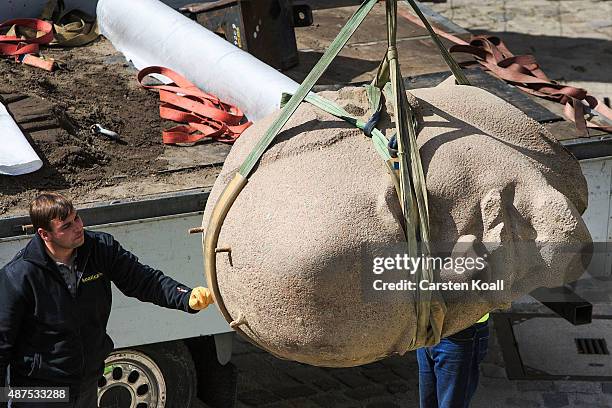 Workers unload the head of a sculpture of Russian revolutionary Vladimir Lenin for an exhibition of monuments in the citadel in Spandau district on...