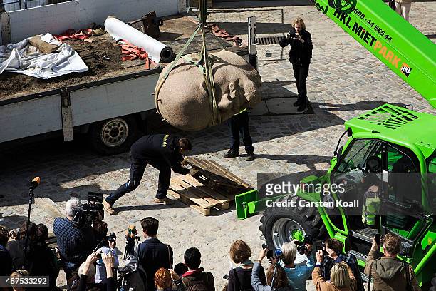 Workers unload the head of a sculpture of Russian revolutionary Vladimir Lenin for an exhibition of monuments in the citadel in Spandau district on...