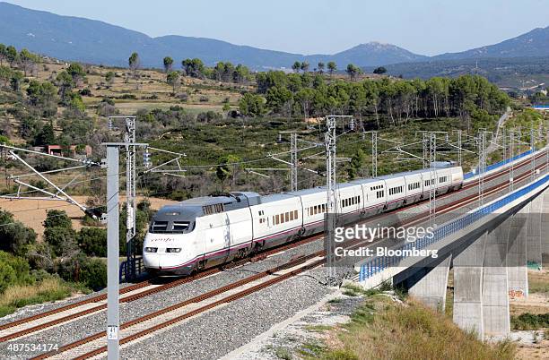 An AVE Class 100 train, operated by RENFE Operadora SC, passes by the Llobregat river viaduct in Llers, Spain on Wednesday, Sept. 9, 2015. TP Ferro...
