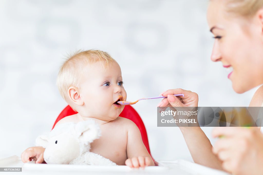 Mother feeding baby with spoon